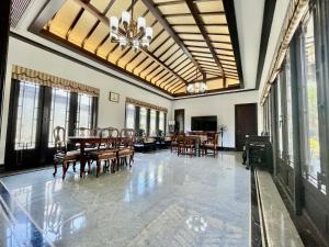 a dining room with a table and chairs and windows at Songlan Tea House · Shanhai Resort Chinese style Courtyard Villa in Xiangshan