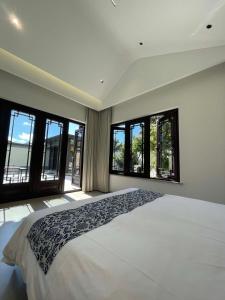 a bedroom with a large bed with large windows at Songlan Tea House · Shanhai Resort Chinese style Courtyard Villa in Xiangshan