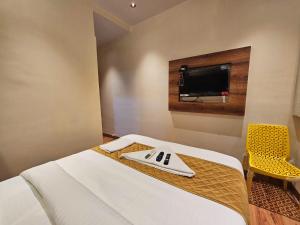a hotel room with a bed and a tv on the wall at Hotel Imperial Suite in Mumbai +25 photos