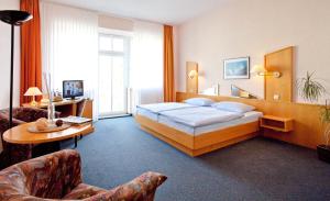 a hotel room with a bed and a table and chairs at Hotel Villa Subklew in Ostseebad Sellin