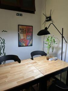 a wooden table with two chairs and a lamp at PROpaganda Hostel in Thong Sala