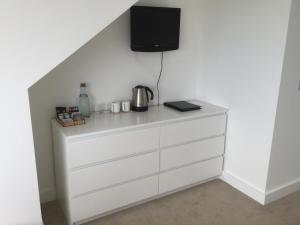 a white dresser with a tv on top of it at Ten Ocean View in St Ives
