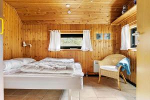 a bedroom with a bed and a window and a chair at TV1575-Skagen-Solbakken-23 in Skagen