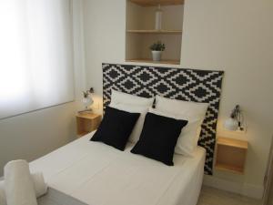 マラガにあるLivemalaga Santa María Apartmentsのベッドルーム1室(ベッド1台、白黒の枕付)
