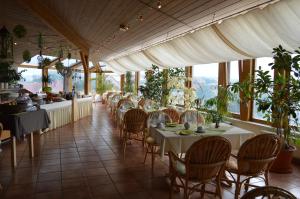 ein Restaurant mit weißen Tischen, Stühlen und Fenstern in der Unterkunft Hotel Stadt Jessen in Jessen
