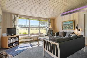 a living room with a couch and a television at TV1383-Hirtshals-Klitmarken-14 in Hirtshals