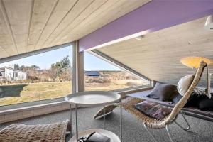 a room with a chair and a table and a window at TV1383-Hirtshals-Klitmarken-14 in Hirtshals