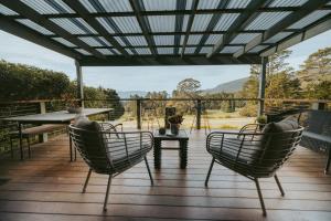 un patio avec des chaises et une table sur une terrasse dans l'établissement Jimmys Cabin - Kangaroos, Kookaburras, Sleeps 4!, à Kangaroo Valley
