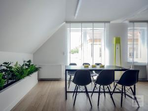 a dining room with a black table and chairs at Ataner Apartamenty in Koszalin