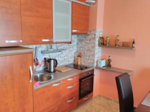 a small kitchen with wooden cabinets and a sink at Apartment Sea Space in Dobra Voda