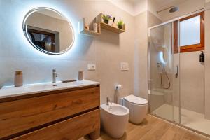 une salle de bain avec un lavabo, des toilettes et un miroir dans l'établissement Ca'Julia, à Venise 42 autres photos