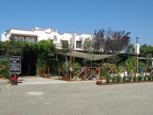 a sign in front of a building with a fence at Hotel La Torricella in Capalbio