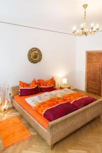 ウィーンにあるGabriele´s Apartmentのベッドルーム1室(大型ベッド1台、オレンジ色の枕付)