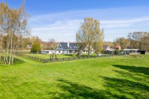 a large field with a fence in front of a house at Dutchies-dk in Væggerløse