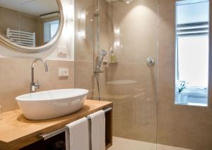 a bathroom with a sink and a shower at Vitalpina Hotel Dosses in Santa Cristina Gherdëina