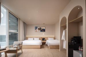 a hotel room with two beds and a window at Langying Intelligent Guesthouse in Sanya +68 photos