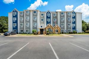 a large building with a parking lot in front of it at Microtel Inn & Suites by Wyndham Searcy in Searcy