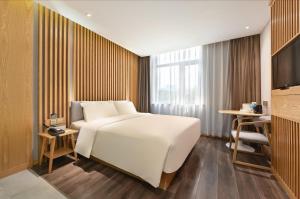 a bedroom with a large white bed and a television at Atour X Hotel Beijing Sanlitun Agricultural Exhibition Hall in Beijing