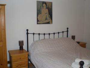 a bedroom with a bed and a painting on the wall at Bluebell and Appletree Cottages in Hockwold cum Wilton