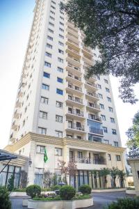 um edifício branco alto com uma bandeira em frente em Quality Suites Vila Olimpia em São Paulo