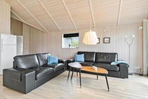 a living room with a black leather couch and a table at TV1459-Jerup-Aaensvej-11 in Jerup +20 photos