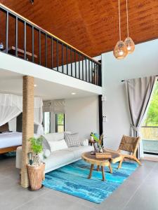 a living room with a white couch and a blue rug at GoldenHour House- Seaview & Sunset in Koh Phangan