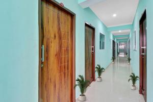 a hallway with a wooden door and potted plants at Super Collection O The Kailash Hotel in Dehradun