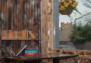 een boekenplank met boeken erop naast een tafel bij Book A Bed Hostels in Londen