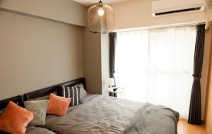 a bedroom with a bed with pillows and a window at SN4B ノワールネスト 都会のシックな隠れ家 Noir Nest urban chic retreat in Nagoya +46 photos