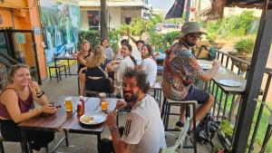 a group of people sitting at tables at a restaurant at Pakse Backpacker Hostel2023 in Pakse