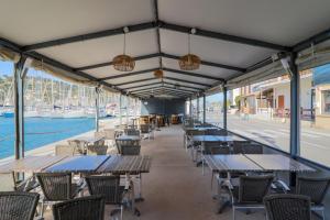a row of tables and chairs in a restaurant at Le Telo in Saint-Mandrier-sur-Mer