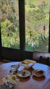 a table with a bowl of food on it with a window at Eco Hotel Balcones de El Carrizal in El Cocuy
