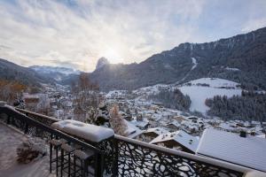 d'un balcon offrant une vue sur la ville dans la neige. dans l'établissement Gran Tubla, à Ortisei 21 autres photos