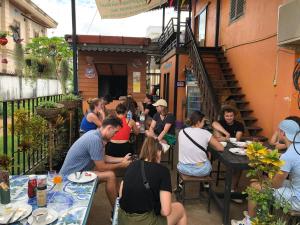 a group of people sitting at tables outside a restaurant at Pakse Backpacker Hostel2023 in Pakse