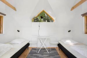 two beds in a room with a table and two chairs at AE240-Aeroskobing-Hanses-Ager-1 in Ærøskøbing