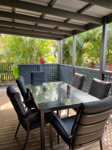 un tavolo da pranzo e sedie su una terrazza di Safety Beach Bungalows a Woolgoolga