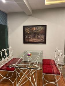 a glass table and chairs in a room at Capital Grande in Dargai