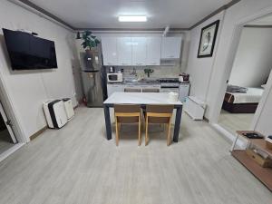 a kitchen with a table and chairs in a room at Gwangalli Tahee House in Busan