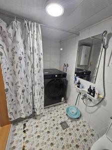 a bathroom with a shower curtain and a sink at Gwangalli Tahee House in Busan +18 photos