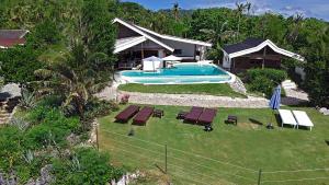 圣胡安Kawayan Holiday Resort的带游泳池的房子的鸟瞰图