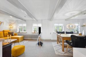 a living room with a table and a yellow couch at AE276-Aeroskobing-Voderup-23 in Ærøskøbing