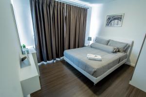 a bedroom with a bed and a large window at Baan Kiang Fah Apartment by Patcha in Hua Hin