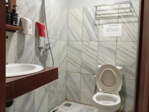 a bathroom with a toilet and a sink at Mas Jenar Guesthose by Kawulastay in Timuran +9 photos