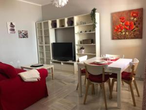 a living room with a table and a tv at Santa Ana - Palacio Del Infantado in Seville