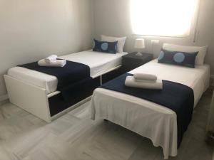 a room with two beds with blue and white at Santa Ana - Palacio Del Infantado in Seville