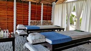 圣胡安Kawayan Holiday Resort的一间设有三张床和木墙的房间