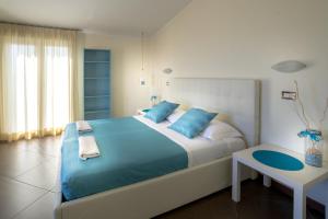 a bedroom with a large bed with blue pillows at Hotel Residence Amarcord in Rimini
