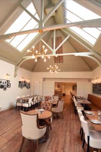 a dining room with tables and chairs and windows at Kirklands Hotel in Kinross