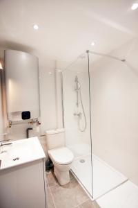 a white bathroom with a toilet and a shower at Appartement plage du Trottel in Ajaccio