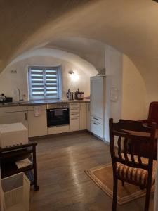 a kitchen with a table and a refrigerator in a room at Antikperle mit Komfort in Hilpoltstein